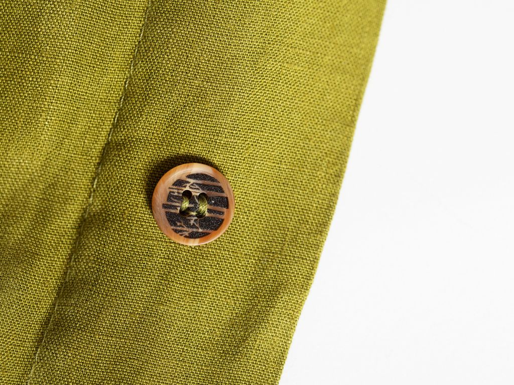Chartreuse green organic linen duvet cover showing a button with The Modern Dane logo on it 