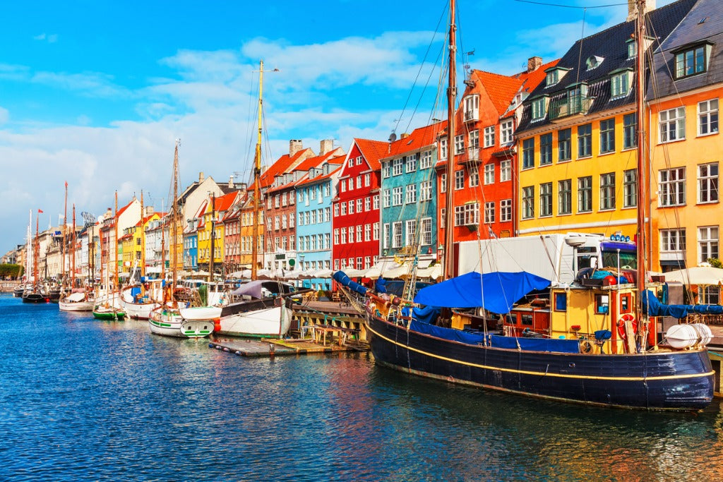 Scenic summer view of Nyhavn pier with color buildings, ships, yachts and other boats in the Old Town of Copenhagen, Denmark