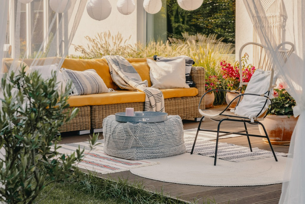 Armchair, pouf as a table and wicker couch on a terrace