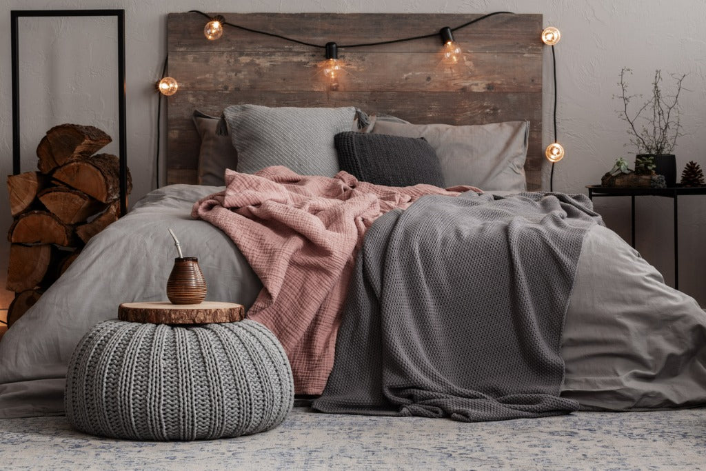 Yerba matte on wooden plate on grey woolen pouf in stylish bedroom interior