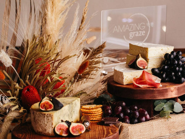 Mesa de pastoreo con flores secas y queso, galletas saladas y frutas.