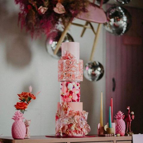 colourful pink multi-tiered wedding cake display using acrylic fillable tier separators