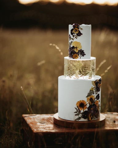 gâteau de mariage sur une planche à gâteau en bois utilisant un niveau remplissable transparent décoré