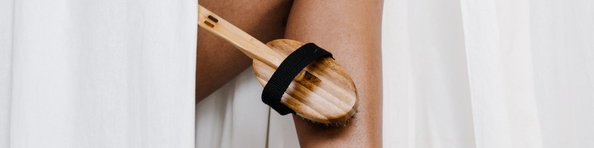 Woman scrubbing body with brush