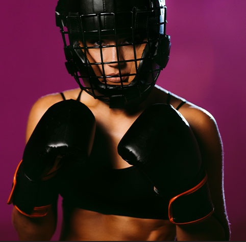 jeune femme qui pratique la boxe avec un casque de protection