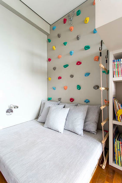 Climbing wall over a bed for kids to climb