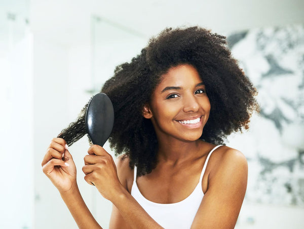 woman with natural hair brushing it