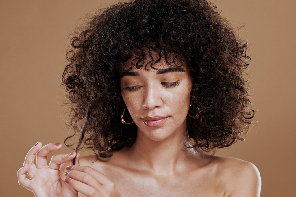 Woman inspecting her curly hair