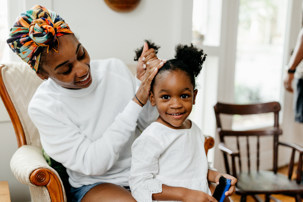 Mother fixing daughters textured hair