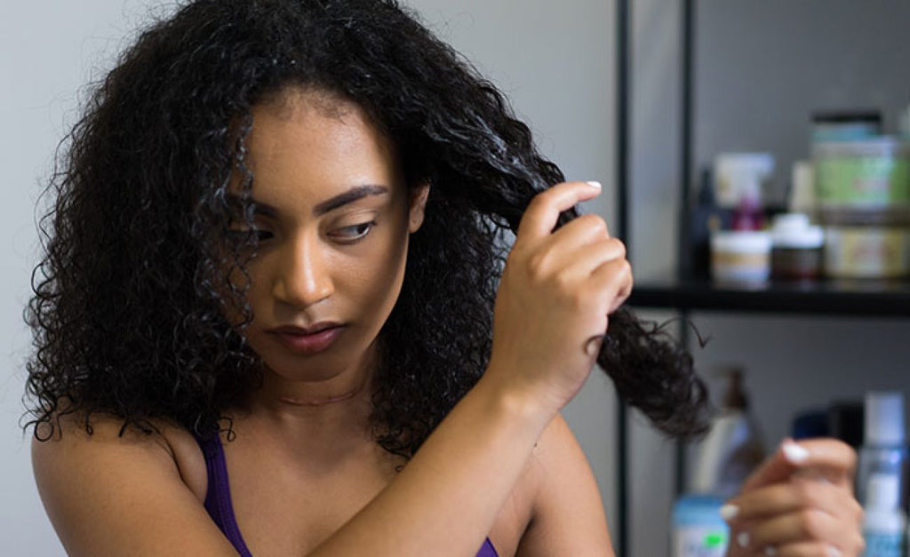 Woman applying deep conditioning treatment to natural curly hair