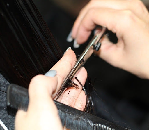 woman getting hair cut trimming ends