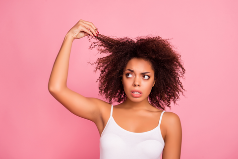 woman with natural curly hair stretching it out