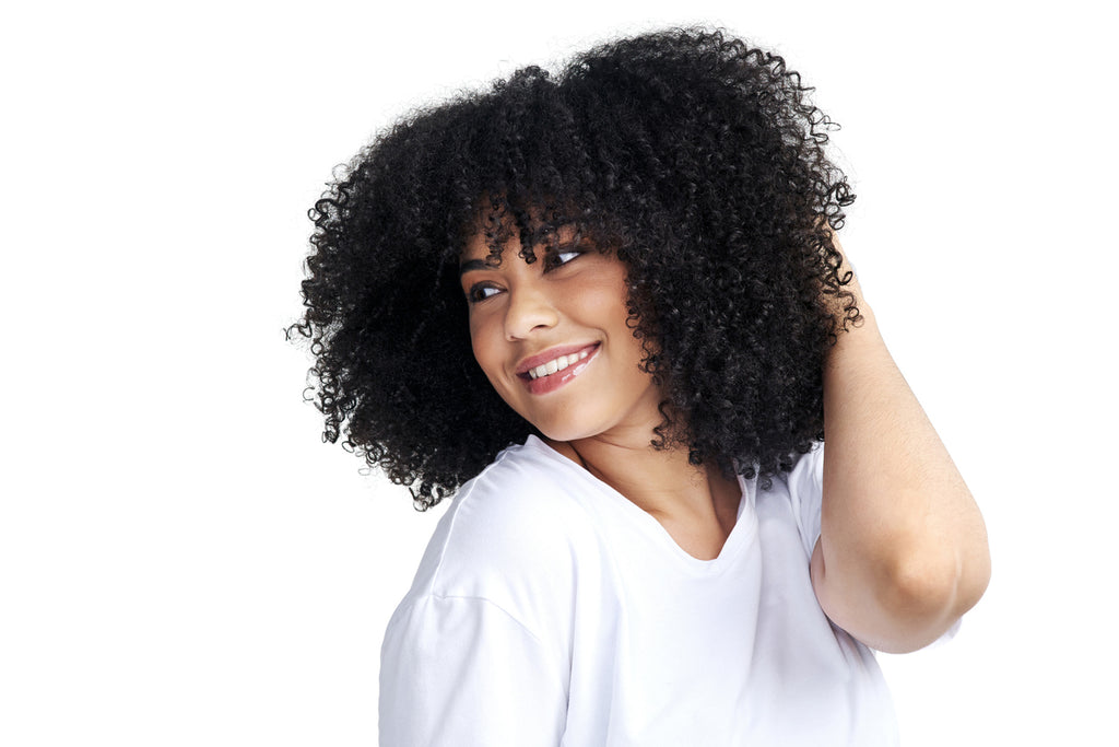 woman-with-coily-hair-posing-against-a-white-background-hair-hacks-concept