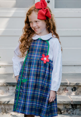 girl in blue plaid jumper with red appliqué flower