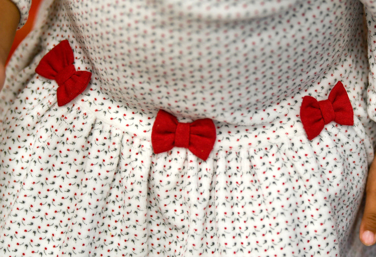 detail of white floral pattern with red bows