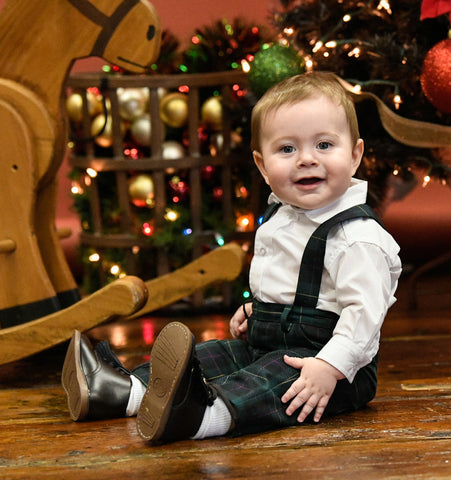 Baby in a green tartan suspender shortall