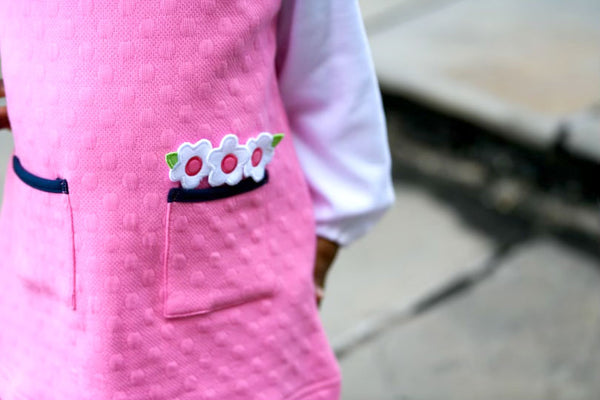 detail image of pink jumper with white flower appliqué