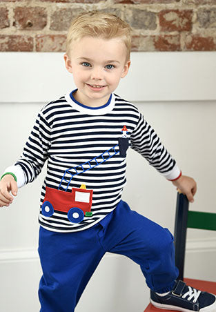 young boy in stripe firetruck long sleeve shirt with puppy