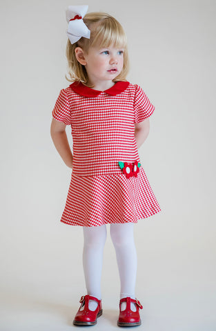 young girl in a red houndstooth dress and matching bow