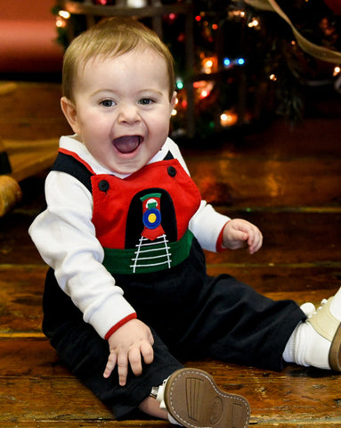 baby boy in train longall smiling