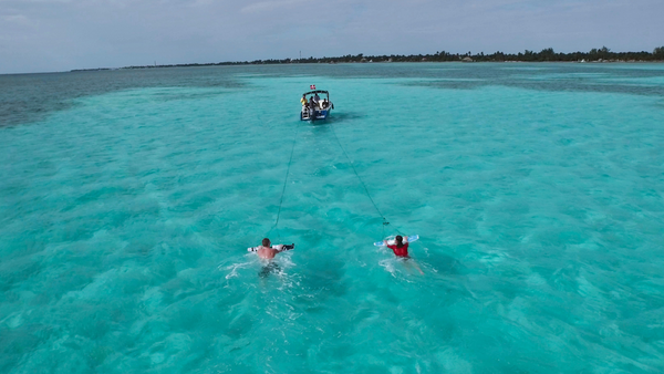 two riders behind boat drone 