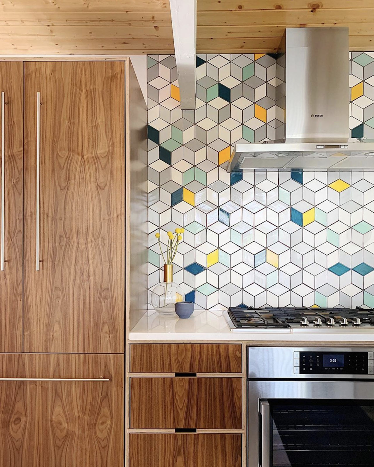 a bright kitchen with teal cabinets, mismatching tile backsplash