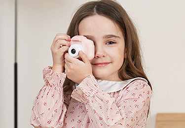 niña usando cámara con lente pequeña