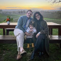Family photo of Prerna with her husband and daughter by the vineyards at Scribe Winery