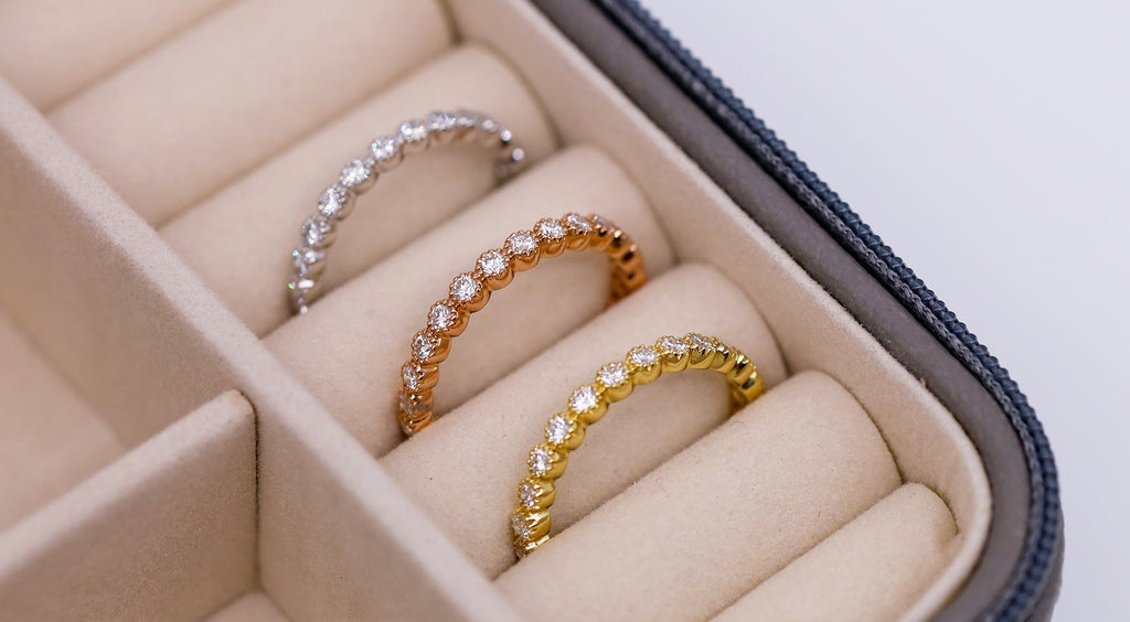Three Bezel Bands in White Gold, Rose Gold, and Yellow Gold tucked into a small jewelry box