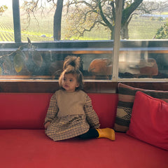 Image of Prerna's daughter, Pia, sitting on a red couch