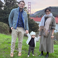 Family photo of Prerna with her husband and daughter in front of the Golden Gate Bridge at Cavallo Point Lodge