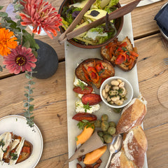 Overhead photo of board with seasonal fruits, nuts, and crostini