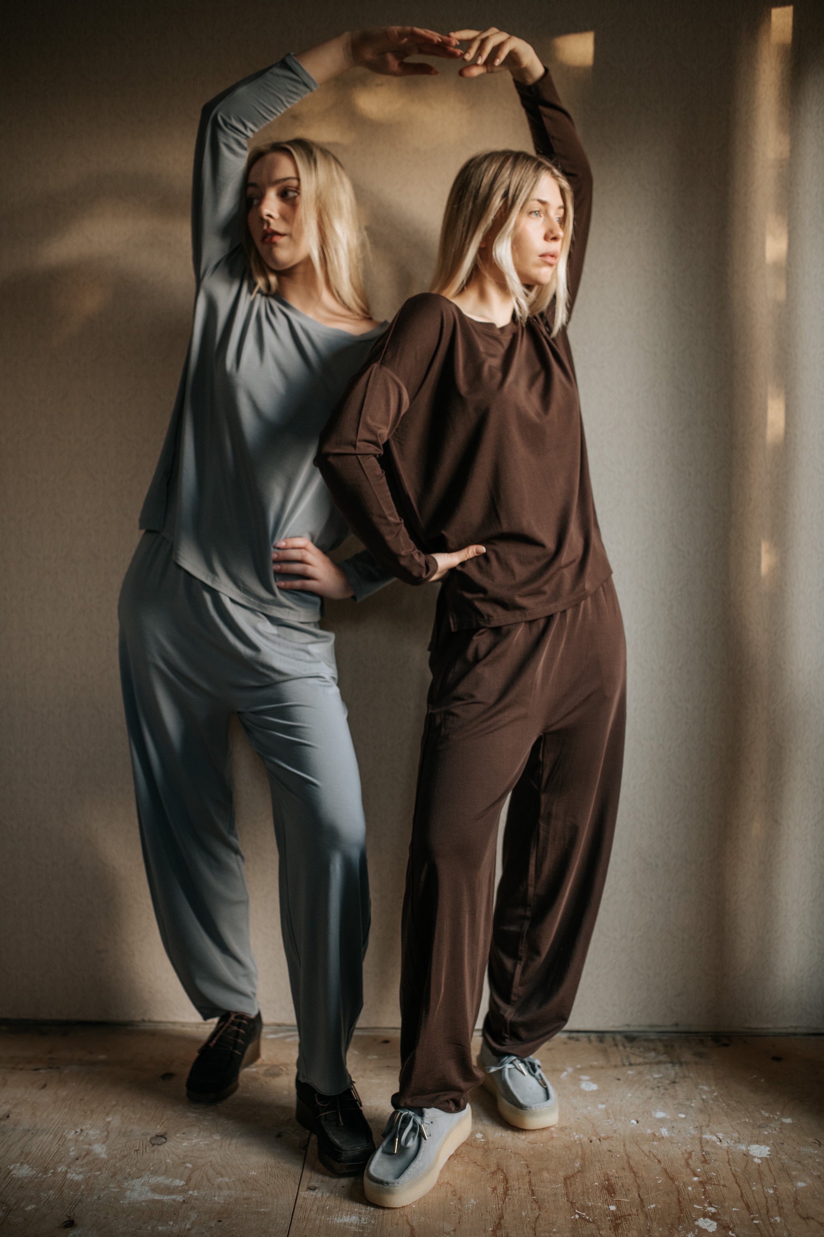 two women dancing in sleep wear sets in brown and blue tones. 