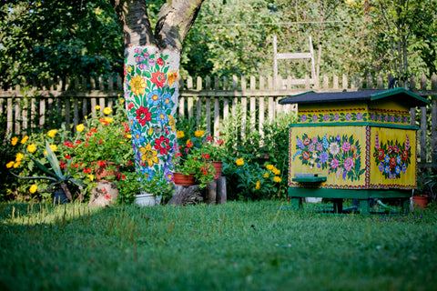 garden view, tree bark and beehive painted in flowery patterns