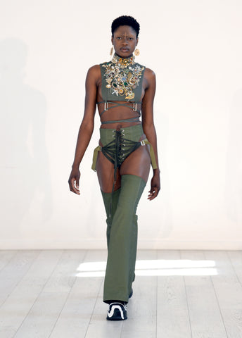 Lula Laora ss22 the garden Getty runway, khaki trousers, fan lacing, khaki bib with antique jewels. 