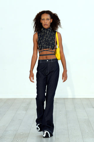 Lula Laora ss22 the garden Getty runway, denim trousers, denim bib top with antique crosses and yellow bag. 