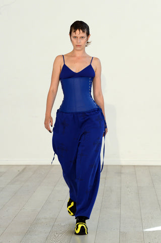Lula Laora ss22 the garden Getty runway, blue bra, and blue sweatpants with a blue leather corset top. 