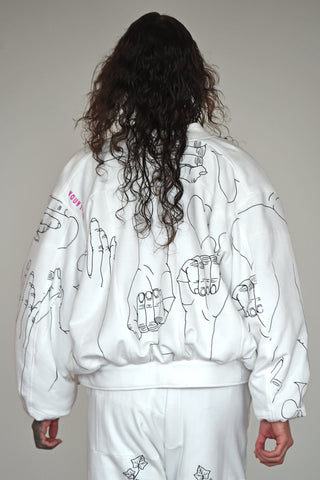 LULA LAORA AW21 Getty Images, the back of menswear model wears a white bomber jacket with black illustrations and white large joggers/sweatpants. 