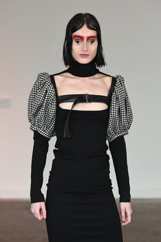LULA LAORA AW21 Getty Images, womenswear model wears fitted back midi dress with a high neck and a cut-out neckline. Also wears a houndstooth harness. 