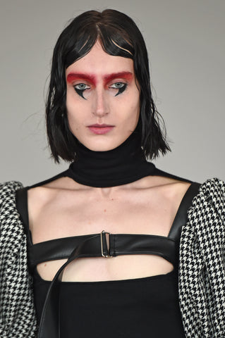 LULA LAORA AW21 Getty Images, womenswear model wears a black high neck and a cut-out neckline. Also wears a houndstooth harness. 