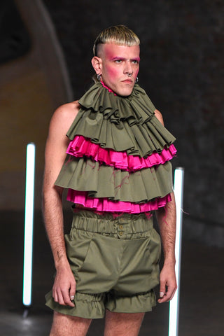 Lula Laora runway Getty pink eyebrows, menswear, ruffled khaki and fuchsia top, bib top, khaki shorts, 