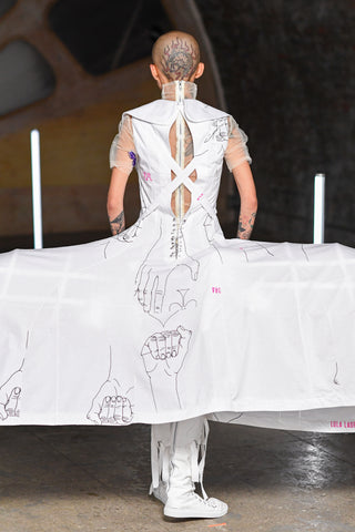 Lula Laora runway Getty pink eyebrows, back of winged white dress, lace up back, short sleeves. 