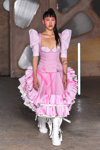 Lula Laora runway Getty pink eyebrows, pink victorian top with puffy sleeves, ruffled midi skirt and white high top laced sneakers