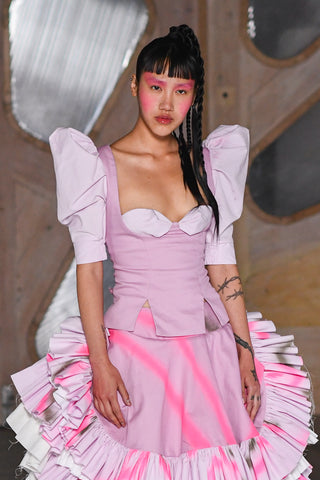 Lula Laora runway Getty pink eyebrows, victorian style top wit puffy sleeves, ruffled neon and pink skirt mid-length