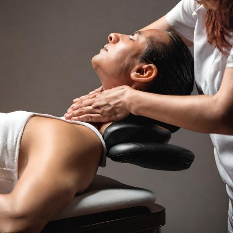 A person giving a neck massage.