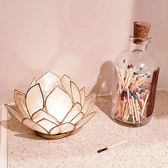 jar of matchsticks with striker, next to candle