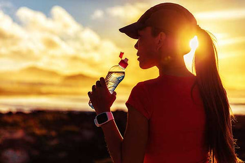 fitness-woman-drinking-water-from-sports-bottle-on-afternoon