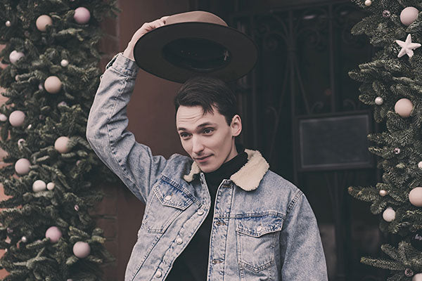 handsome stylish man greets by removing his hat from his head