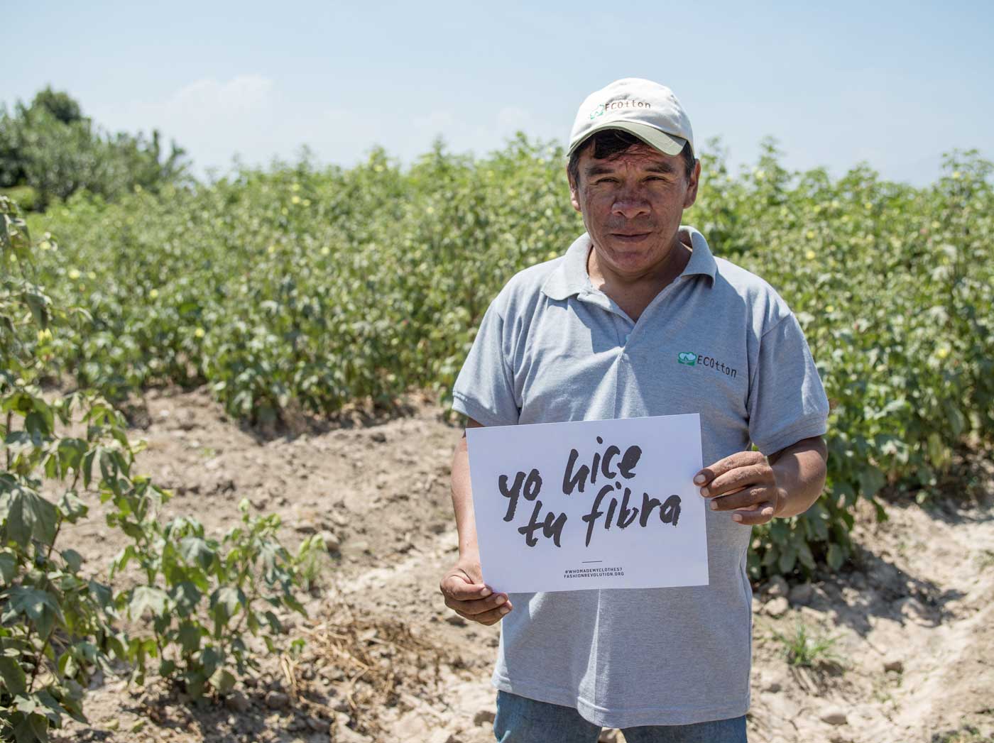 Organic cotton farmer in Peru holding Fashion Revolution sign: Yo hice tu fibra. Fair trade clothing brand. 