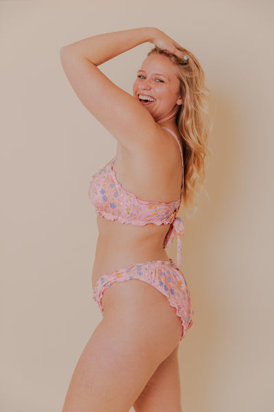 Model wearing a pink floral ruffled bikini.